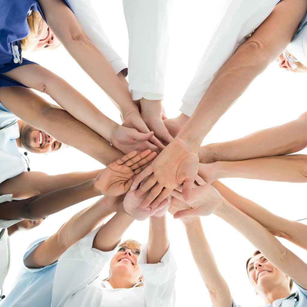 Multiethnisches medizinisches Team reicht sich die Hände