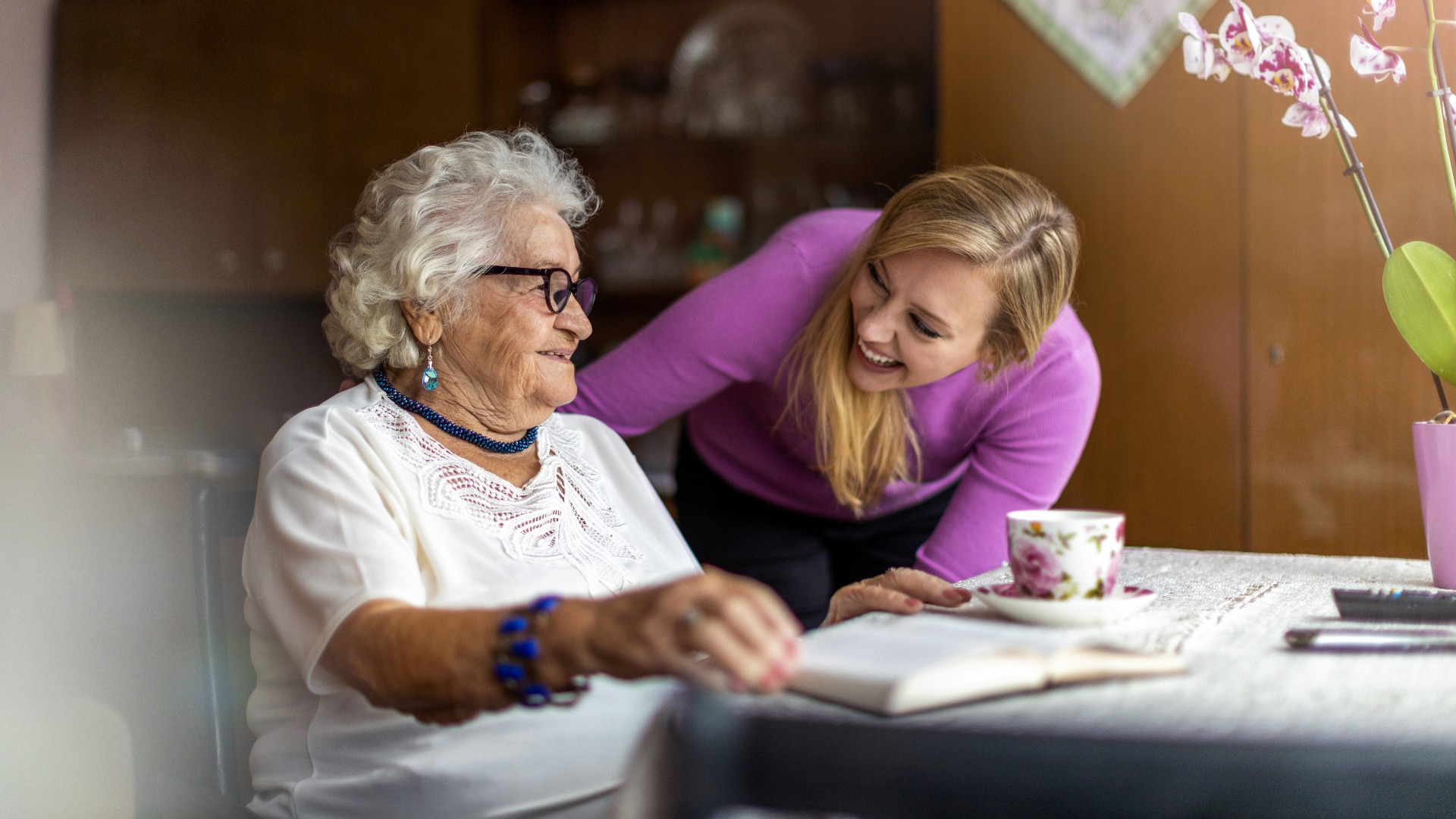 Young woman spending time with her elderly grandmother at home